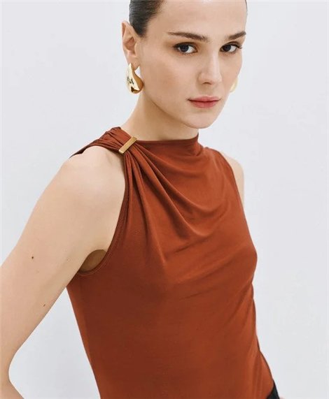 Acces Blusa bronce satinada con broche