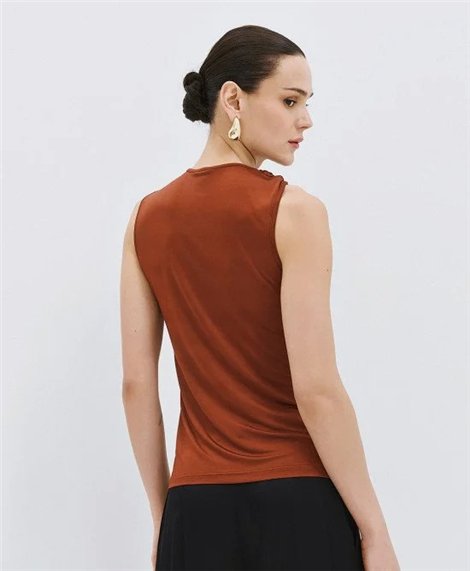 Acces Blusa bronce satinada con broche